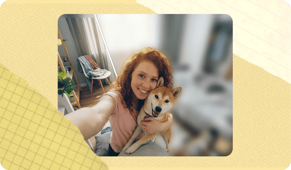 Woman with curly red hair taking a selfie with her Shiba Inu dog indoors, with a blurred background effect applied